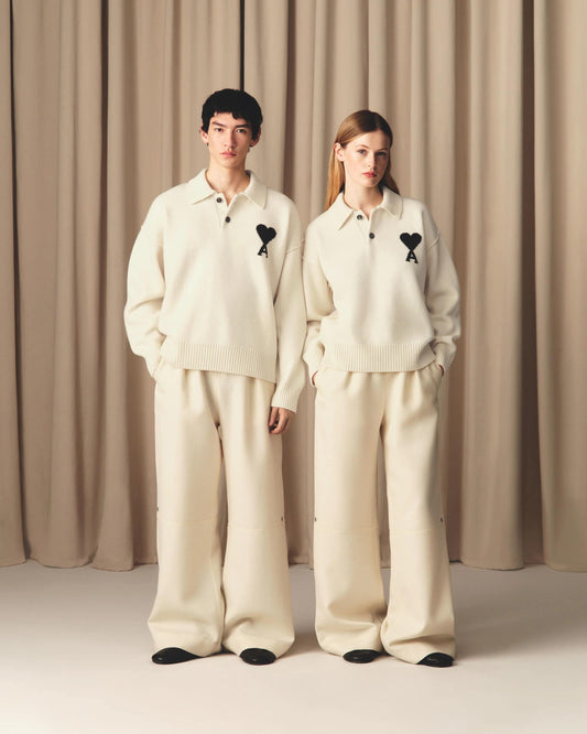 couple wearing matching outfits with Ami De Coeur White Wool Polo Sweater UPL409.018.151 against a beige curtain background