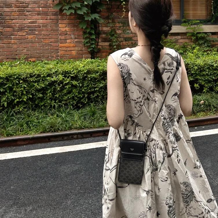 mẫu mang túi CELINE PHONE POUCH WITH FLAP IN TRIOMPHE CANVAS AND LAMBSKIN BLACK 10G332CQD.38SI