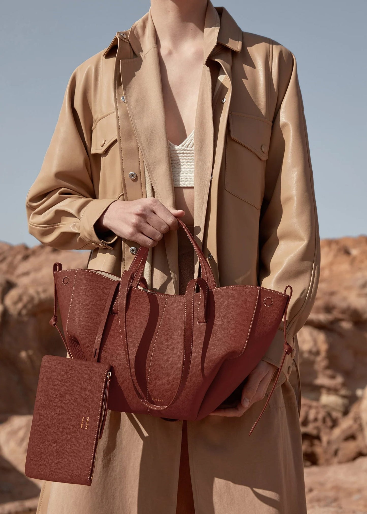 Person holding a Cyme Mini Edition Textured Cognac BHB0018MGRBR418 in a desert setting