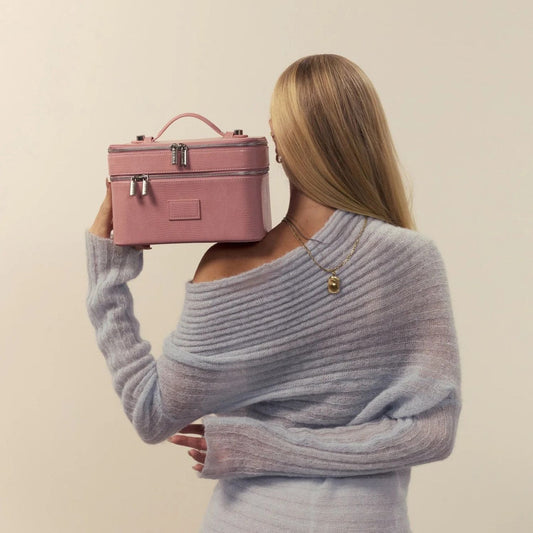 Person holding a Étoile Duo Vanity Case Crush Limited Edition against a beige background