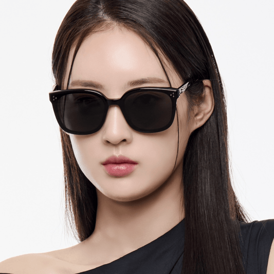 Woman wearing GENTLE MONSTER BY 01 with a plain background