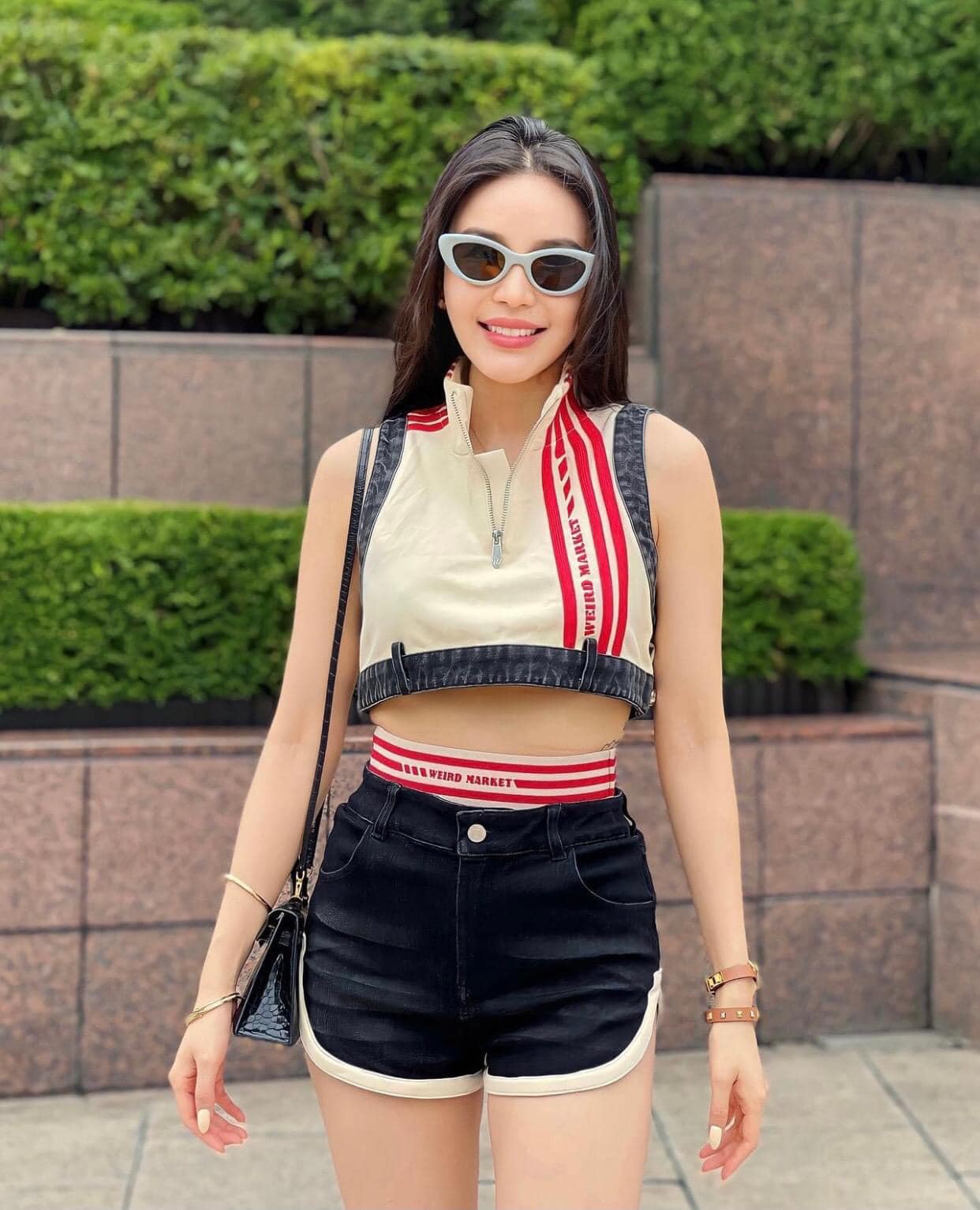Woman wearing a crop top with suspenders and Gentle Monster (GM) Conic G6 outdoors