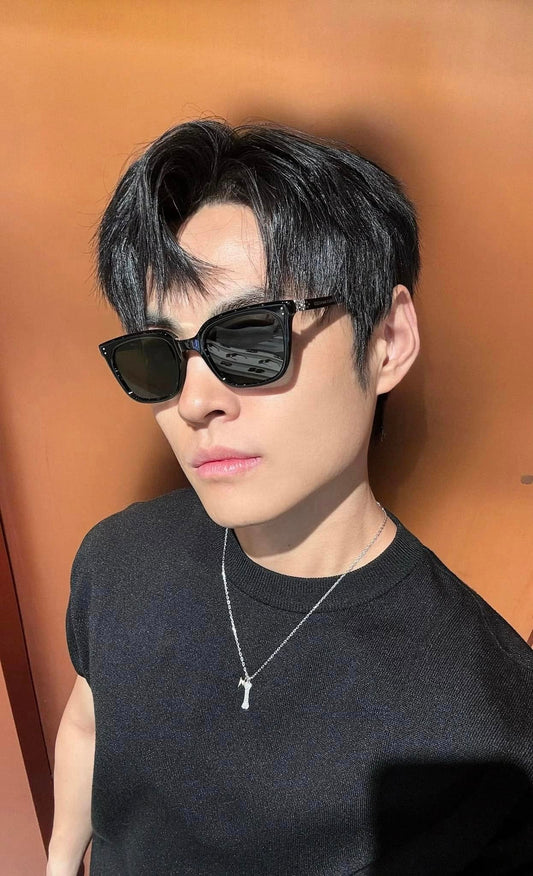 Man wearing Gentle Monster (GM) Matiny 01 and a black shirt against an orange background