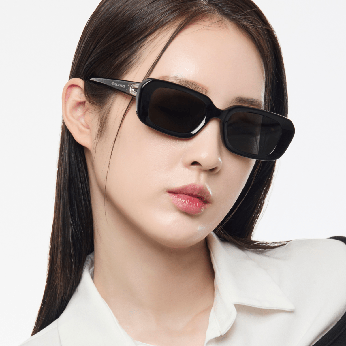 Woman wearing black sunglasses with a plain background