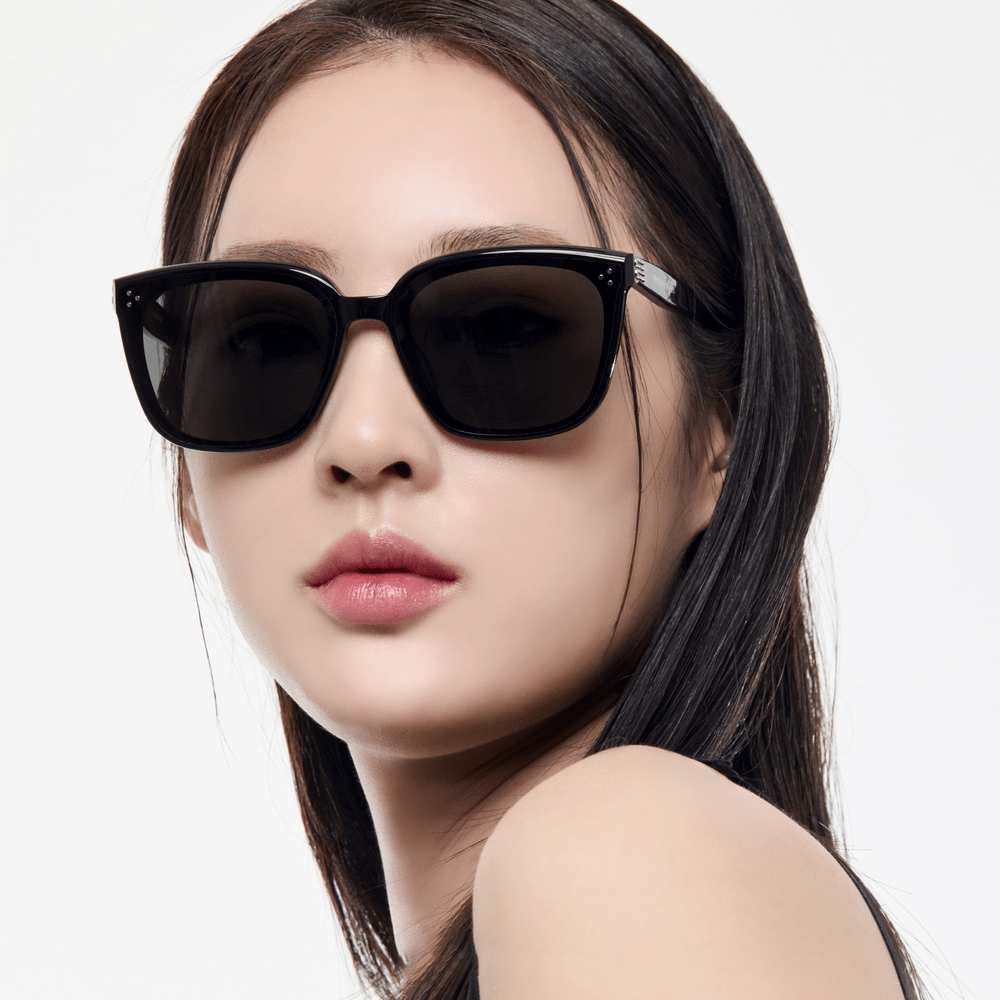 Woman wearing black sunglasses on a white background