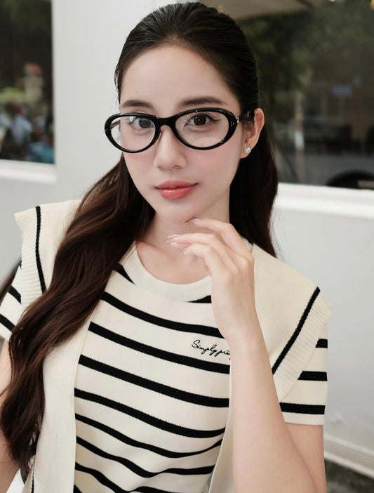 Woman wearing Gentle Monster (GM) Orbit 01 and a striped shirt with a blurred background