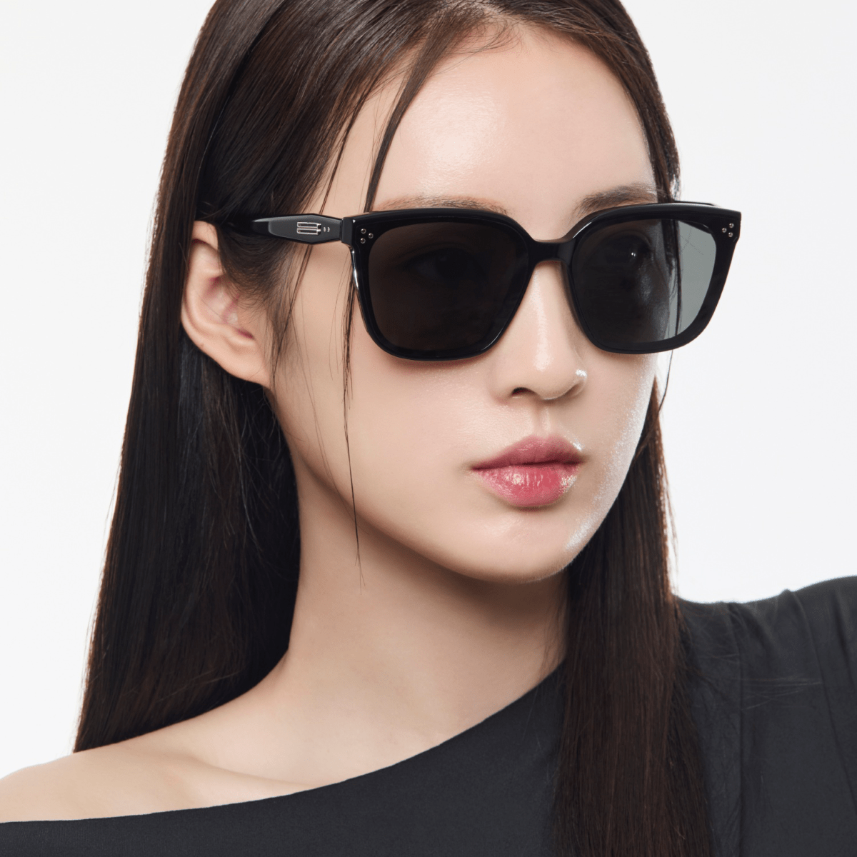 Woman wearing black sunglasses with a plain background