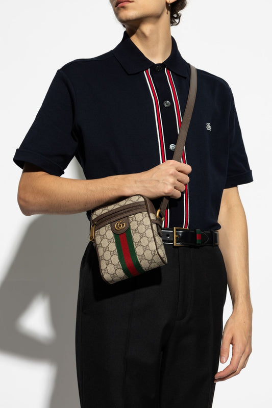 Person wearing a black polo shirt with a red and white stripe holding a Gucci GG Supreme Ophidia Shoulder Bag 598127 96IWT 8745