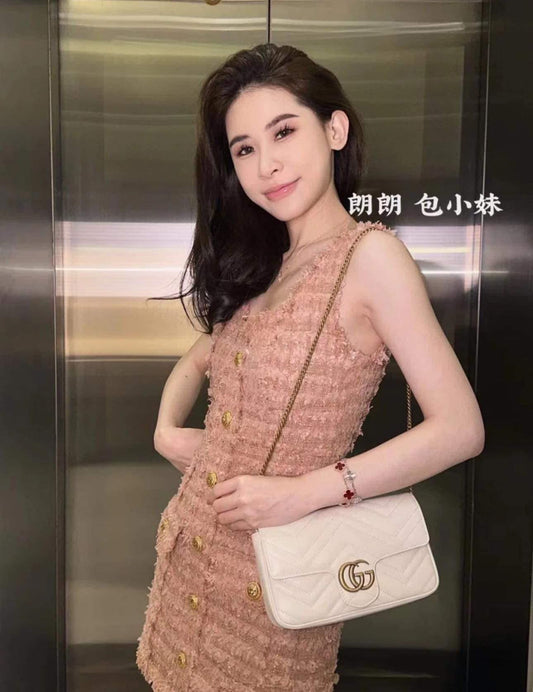 Woman in a textured dress holding a Gucci Marmont White Small Bag with Card Case 751526 AACCE 9053 in an elevator.