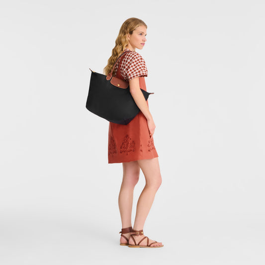 Woman holding a Longchamp Le Pliage Original Tote Bag L – Black L1899089001 on a white background
