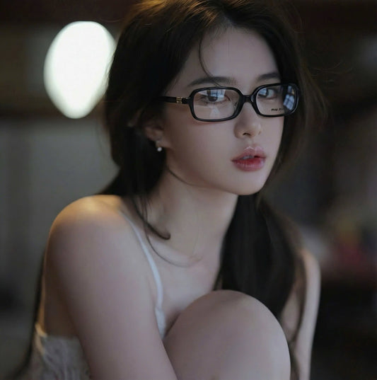 Woman wearing Miu Miu 01YV 16K1O1 Square Eyeglasses in a dimly lit room