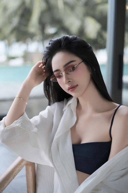 Woman wearing Miu Miu MU A54S ZVN70O Logo Sunglasses Gradient Pink Lenses SMUA54_EZVN_FE70O_C_051 and a white shirt with a blurred background