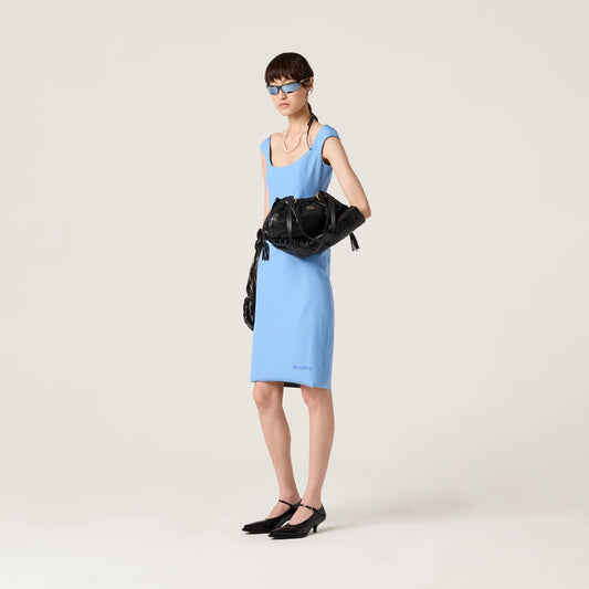 Woman in a blue dress holding a Miu Miu Black Joie Nappa Leather Bag 5BG306_ACSW_F0002_V_OOO against a white background