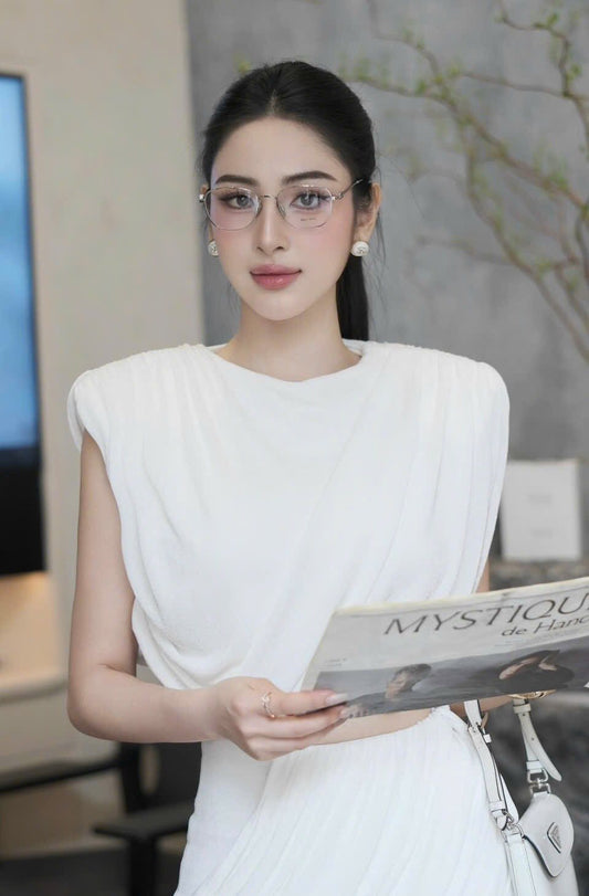 Woman wearing Miu Miu MU 50WV 1BC1O1 Eyeglasses in a white dress holding a magazine titled 'Mystique de Haute Couture'.