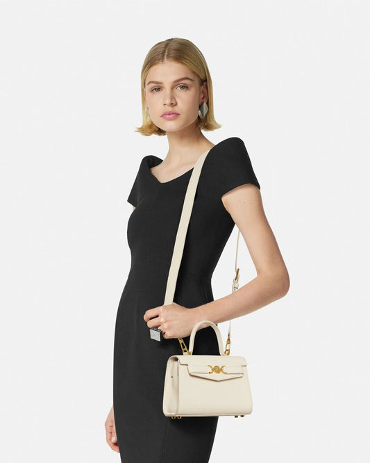 Woman holding a Versace Medusa '95 Small Handbag Cream 1013824 1A10795 1KD7V against a white background