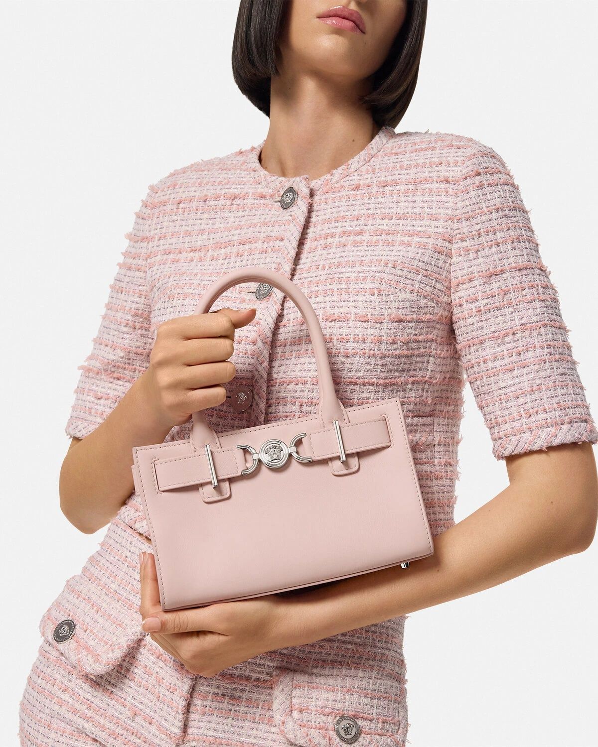 Woman holding a Versace Medusa '95 Small Tote Bag Light Pink 1013169-1A10795_1PT2P against a light background