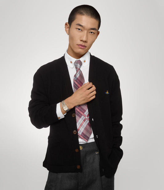 Man wearing a black cardigan over a white shirt with a Vivienne Westwood Hoxton Dual-Tone Silver Watch VV332SLSG 8050164231880 on a light gray background
