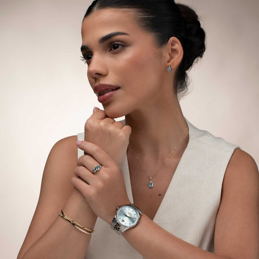 Woman wearing a Vivienne Westwood Seymour Blue Dial Silver Watch vv240lgrsg, bracelet, and ring with a neutral background