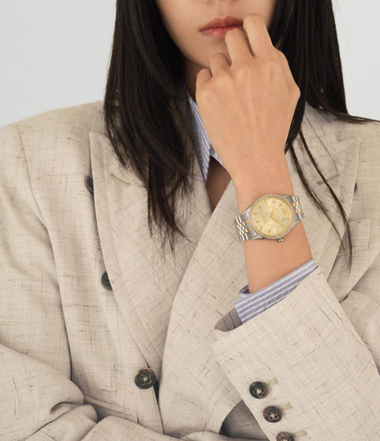 Person wearing a Vivienne Westwood Wallace Watch Gold Dial Silver Watch VV208CPSG on a light gray background