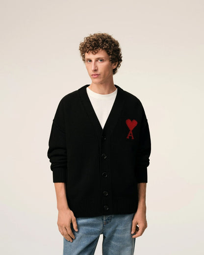 Person wearing a Wool Ami De Coeur Cardigan Black/Red – Felted Merino Wool UKC367.018.009 with a red heart design on a plain background