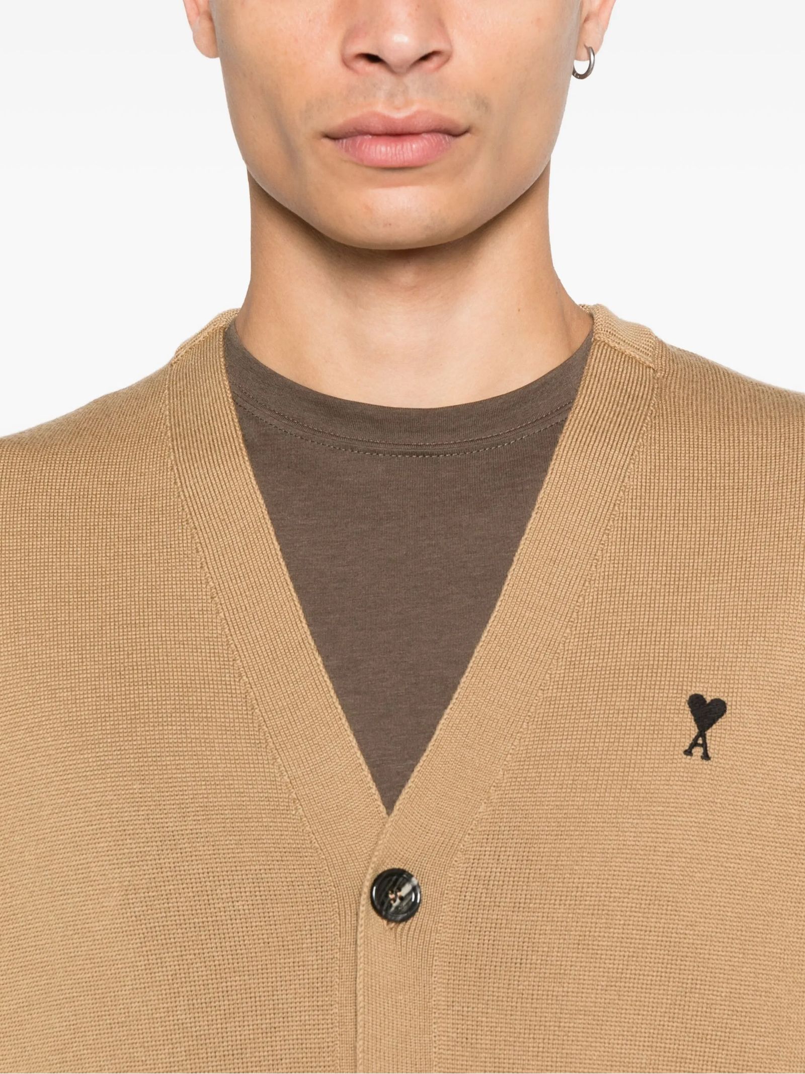 Man wearing a Wool Ami De Coeur Cardigan Camel/Black HKC361.001.288 over a brown shirt with a visible brand logo.