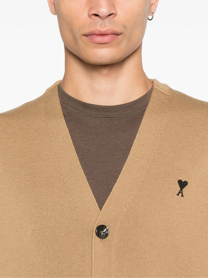 Man wearing a Wool Ami De Coeur Cardigan Camel/Black HKC361.001.288 over a brown shirt with a visible brand logo.