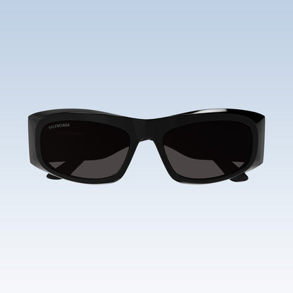 Balenciaga BB0395S 001 Black Rectangular Sunglasses with a glossy black acetate frame and dark tinted lenses, shown against a light blue gradient background.