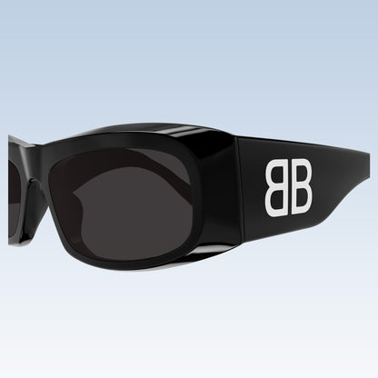 Balenciaga BB0395S 001 Black Rectangular Sunglasses with dark lenses and a bold white 'BB' logo on the temple, shown against a light blue gradient background.