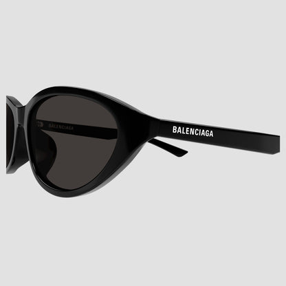 Balenciaga BB0404SK 001 Black Oval Sunglasses with a glossy black frame and dark gray lenses, featuring the Balenciaga logo printed in white on the temple arm.