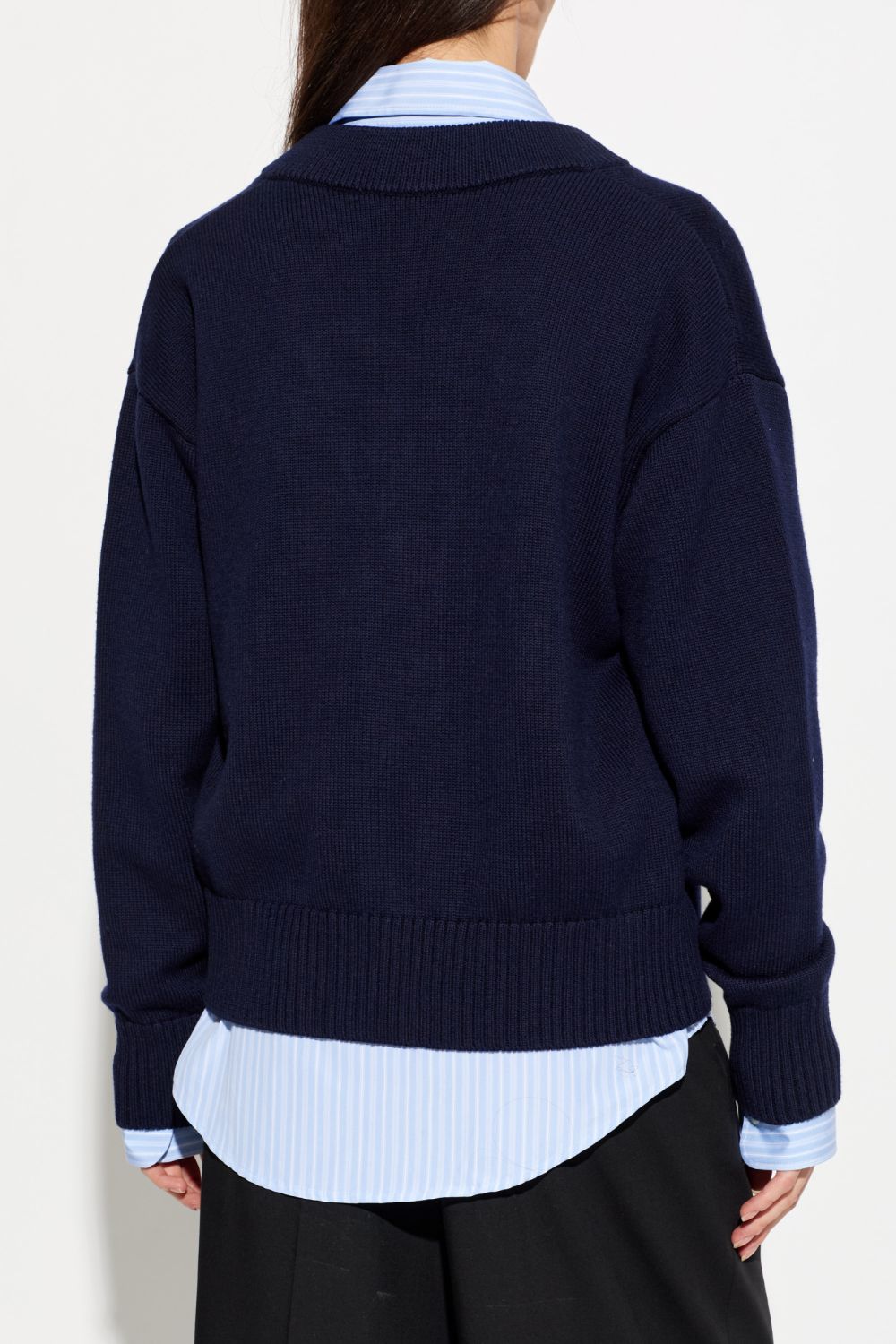 Person wearing a Ami Paris Blue Wool Ami De Coeur Cardigan UKC380.KN0156.A116 over a light blue shirt on a white background