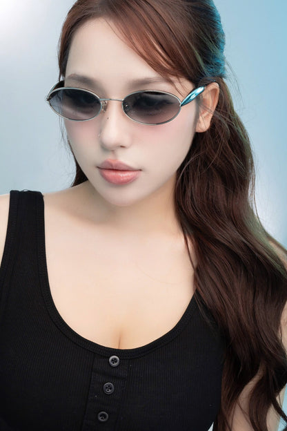 Woman wearing Bottega Veneta BV1386S 007 Silver Sunglasses with a light blue background