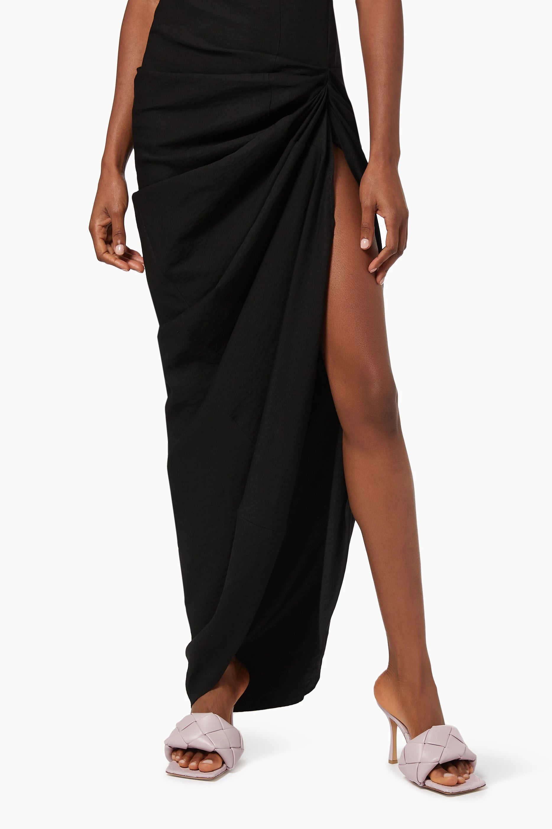 Black draped dress with a Bottega Veneta Lido Mule Magnolia 608854VBSS06955 on a white background