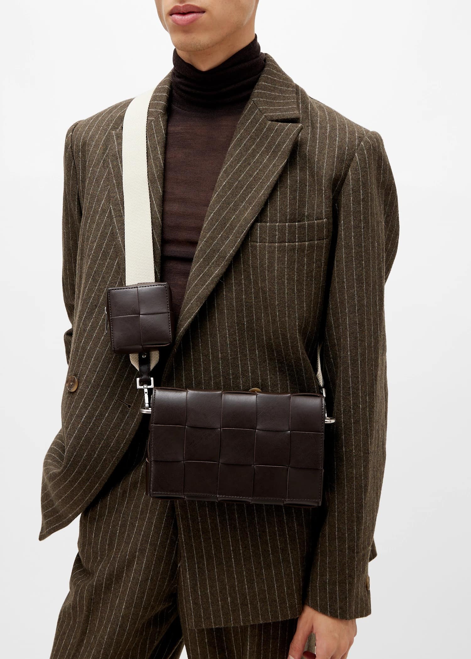 Person wearing a brown pinstripe suit with a Bottega Veneta Medium Brown Cassette Shoulder Bag With Versatile Strap 741777V2XU12094 on a white background