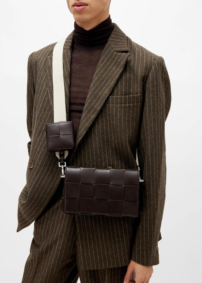 Person wearing a brown pinstripe suit with a Bottega Veneta Medium Brown Cassette Shoulder Bag With Versatile Strap 741777V2XU12094 on a white background