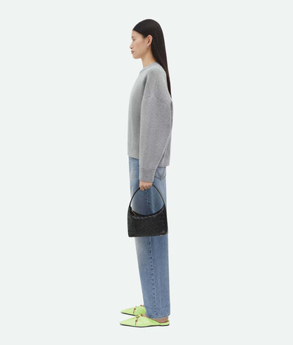 Woman holding a Bottega Veneta Mini Wallace Black 754443V3IV18425 on a white background
