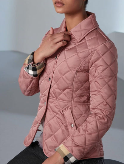 Person wearing a Burberry Cawthorne Quilted Jacket Pink 81114581 a checkered sleeve against a neutral background