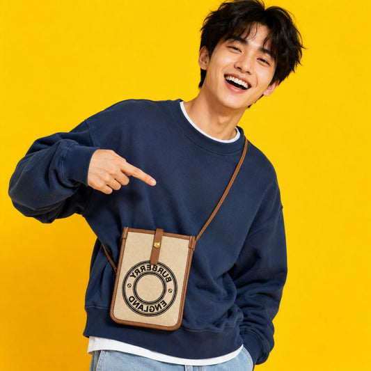 Person wearing a navy blue sweatshirt with a Burberry Logo Graphic Canvas Phone Pouch against a yellow background