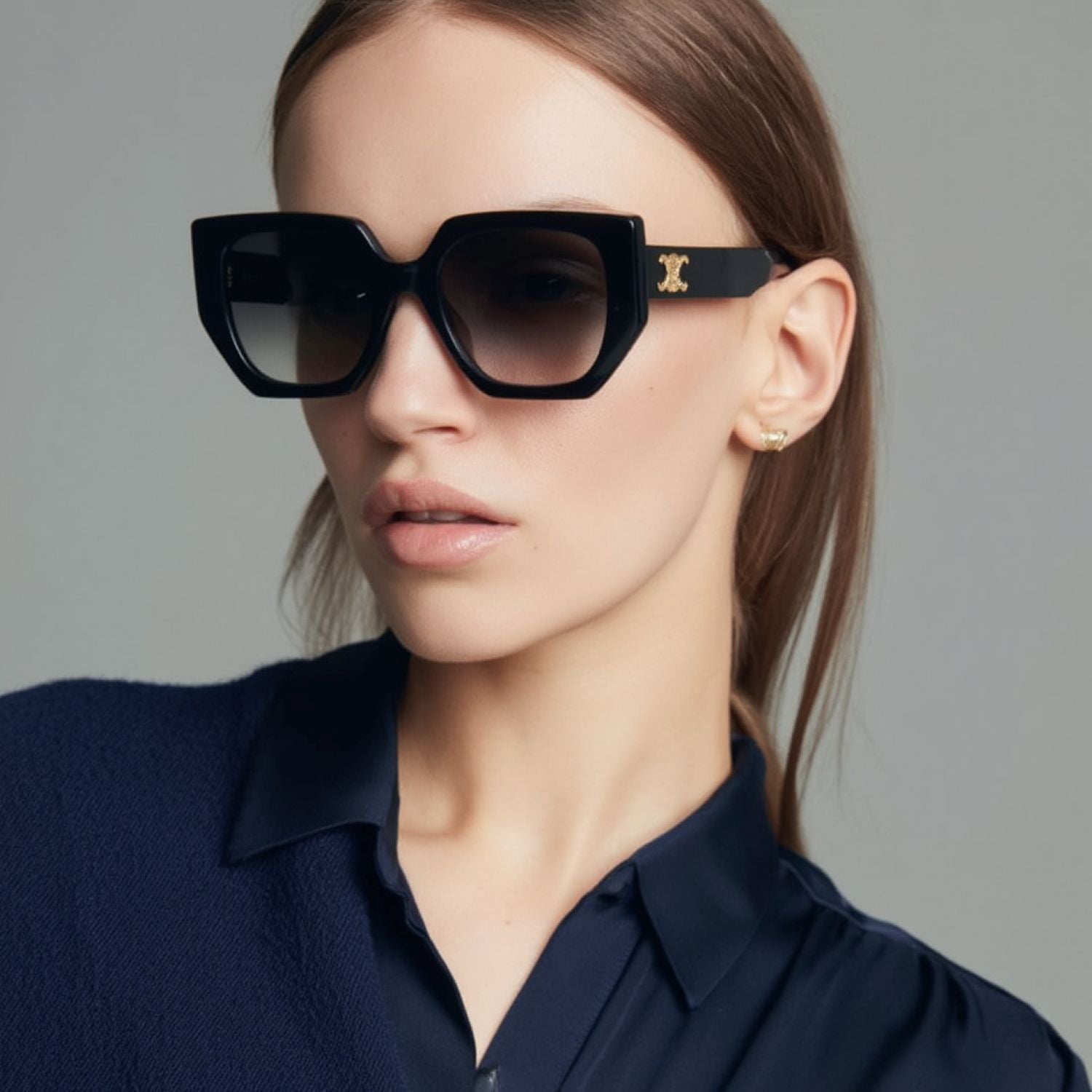Woman wearing black Celine CL40239F 01F Butterfly Triomphe Sunglasses In Acetate with a gold logo on a gray background