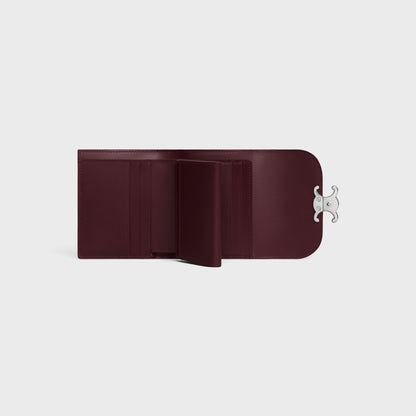 Open Celine Small Flap Wallet TRIOMPHE in Shiny Calfskin Deep Burgundy / Silver 10D783DPV.28DC with a silver clasp on a light gray background