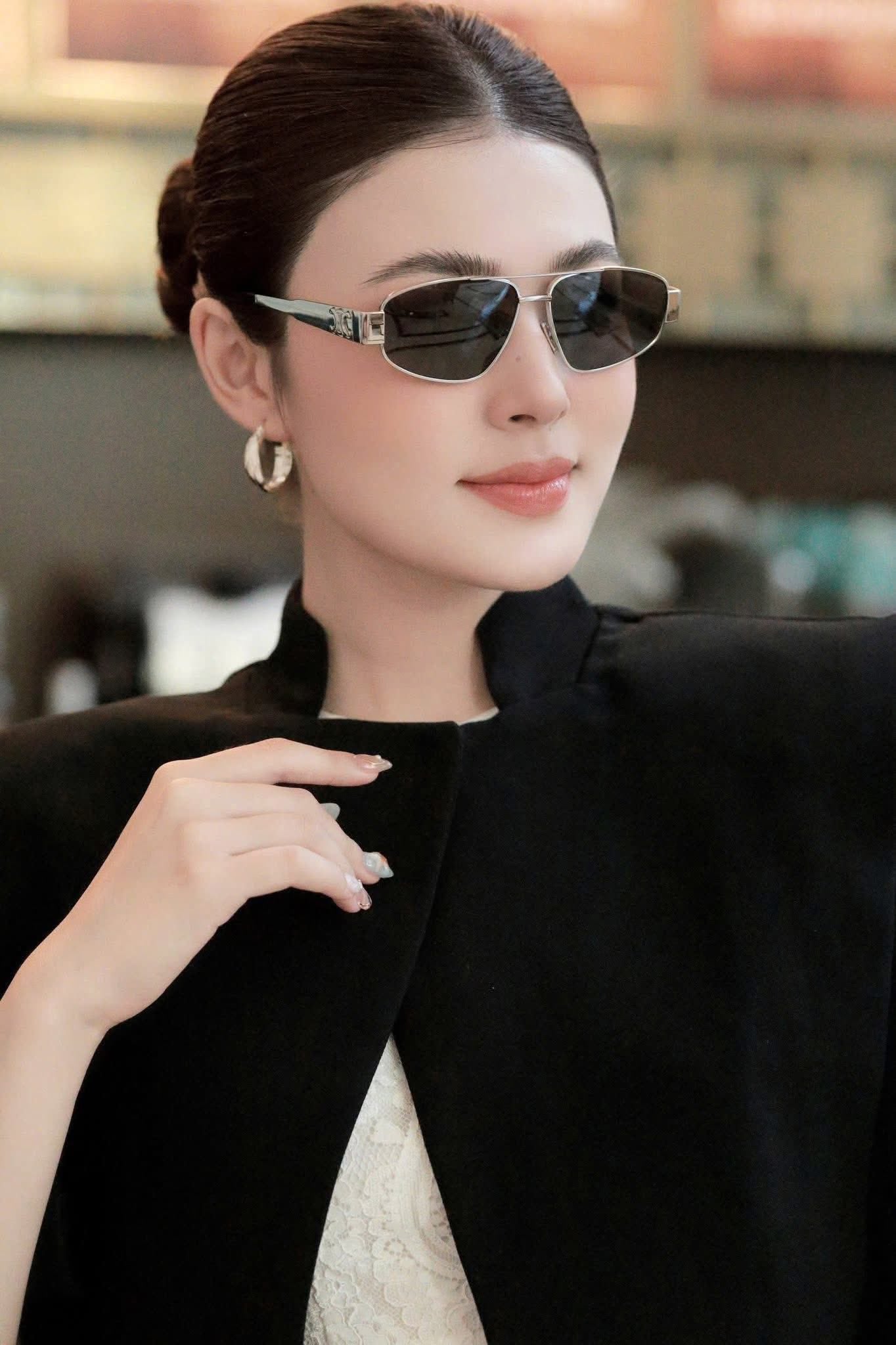 Woman wearing Celine Triomphe Metal 03 Sunglasses in Metal – CL40281U 16A with a blurred indoor background