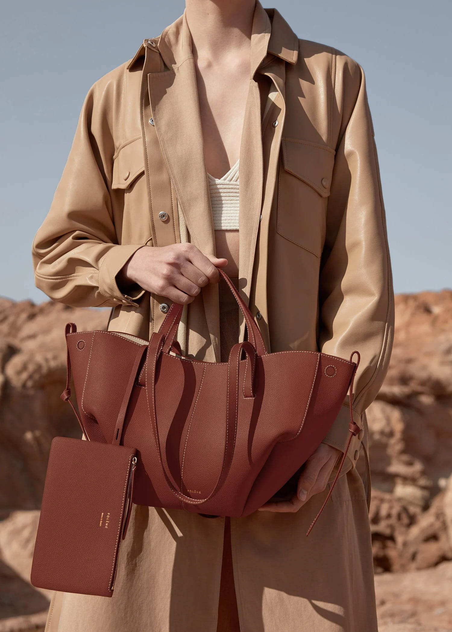 Person holding a Cyme Mini Edition Textured Cognac BHB0018MGRBR418 in a desert setting