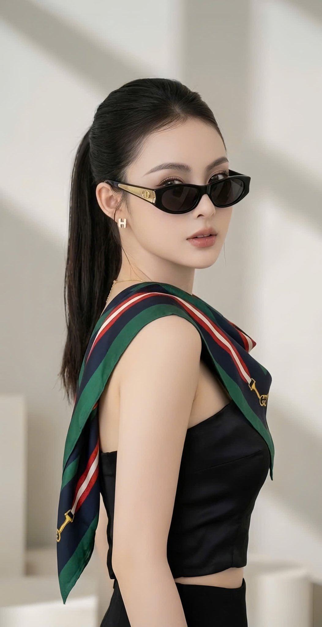 Woman wearing Dior DiorGlow B2F 10A0 Butterfly Sunglasses and a colorful scarf against a neutral background