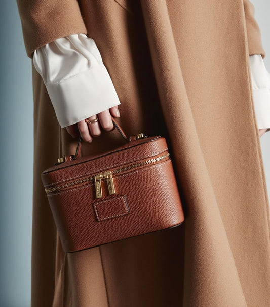 Person holding a Etoile Mini Vanity Case Ginger Brown with a neutral background