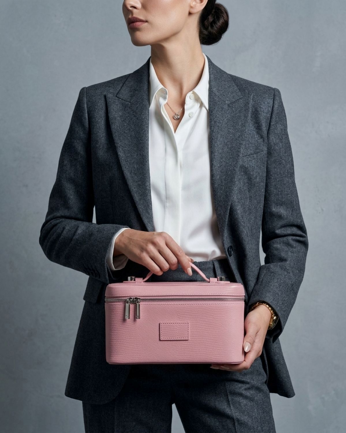 Person in a gray suit holding a Étoile Vanity Case Crush Limited Edition against a gray background