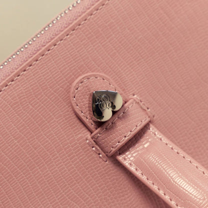 Close-up of a Étoile Vanity Case Crush Limited Edition with a heart-shaped clasp on a light green background