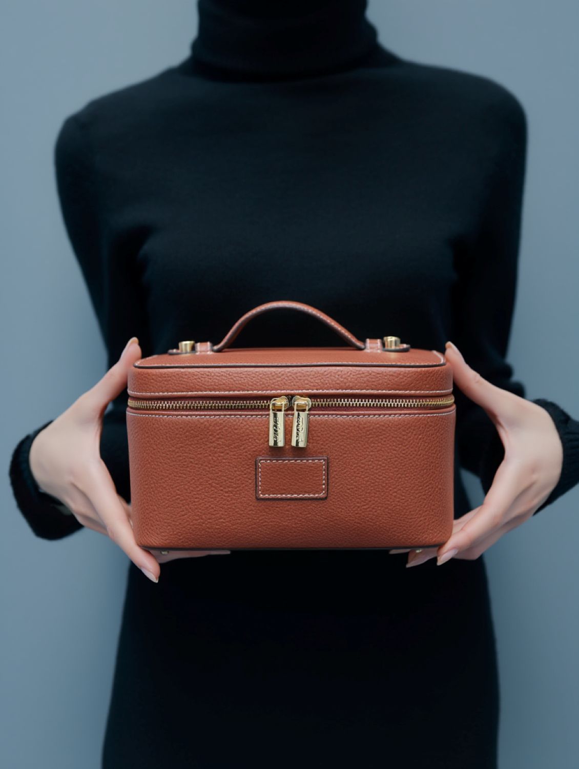 Person holding a Etoile Vanity Case Ginger Brown against a plain background
