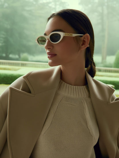 Woman wearing FE40202I 25E — FendiGraphy Cat-Eye Sunglasses with 'FENDI' branding, sitting inside a vehicle.