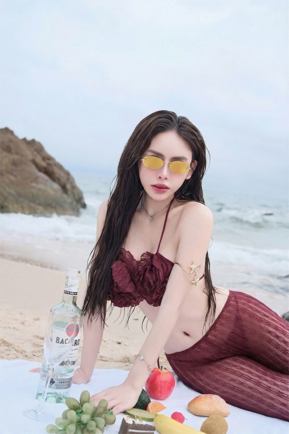 Woman in a burgundy outfit with Fendi FE4075US 30L First Crystal Sunglasses Gold on a beach setting