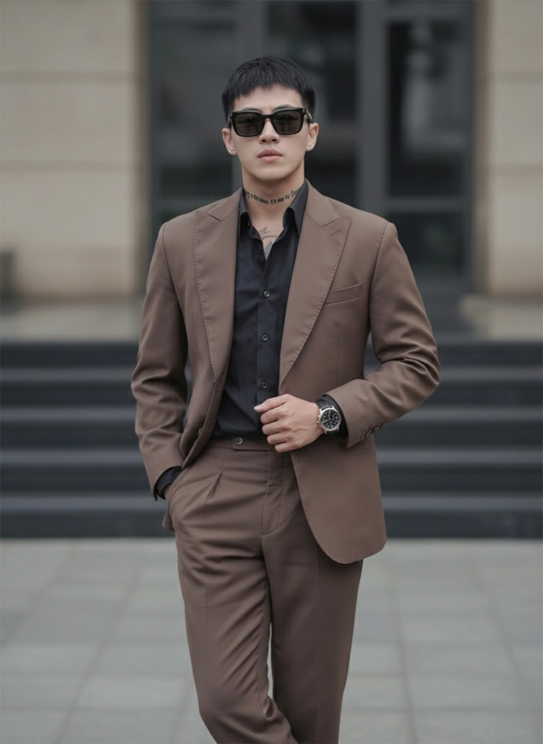 Man wearing a brown suit and Gentle Monster Daze 01 standing outdoors.