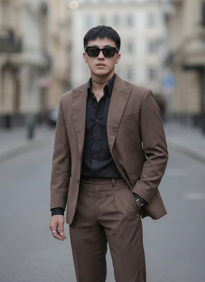 Man in a brown suit and Gentle Monster Daze 01 standing on a city street.
